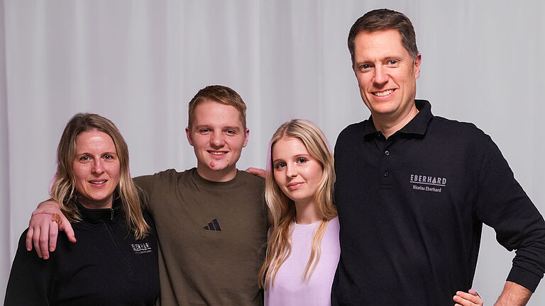 Gruppenbild der Famiile Eberhard: Links die Mutter, daneben die Kinder Lars und Lea und der Vater Nico. Sie alle stehen Arm in Arm und schauen freundlich in die Kamera. 