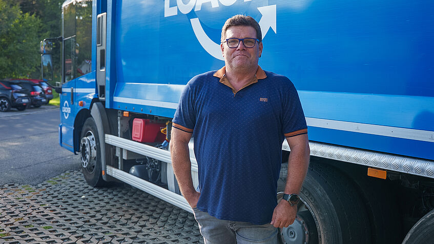 Harald Kleinbub steht vor einem Müllsammelfahrzeug der Loacker Recycling GmbH