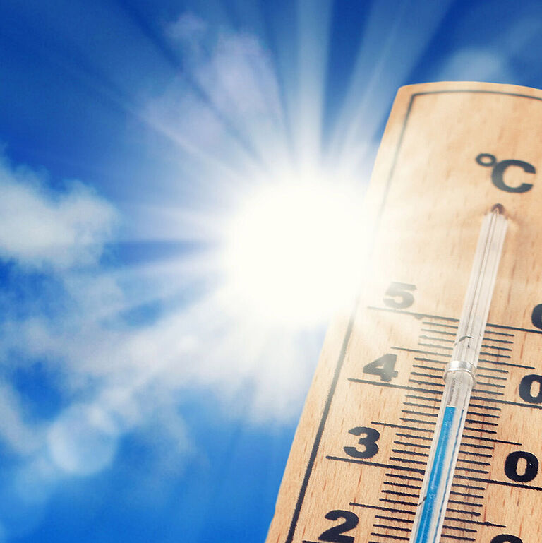 Ein Thermometer zeigt 38 Grad Celsius an, im Hintergrund die gleißende Sonne, Himmel und Wolken