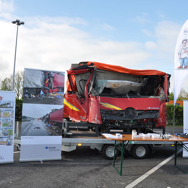 Ein Messestand ist aufgebaut und gezeigt wird eine unfallbedingte zerstörte LKW Kabine.