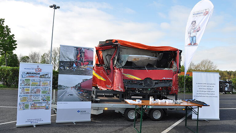 Ein Messestand ist aufgebaut und gezeigt wird eine unfallbedingte zerstörte LKW Kabine.