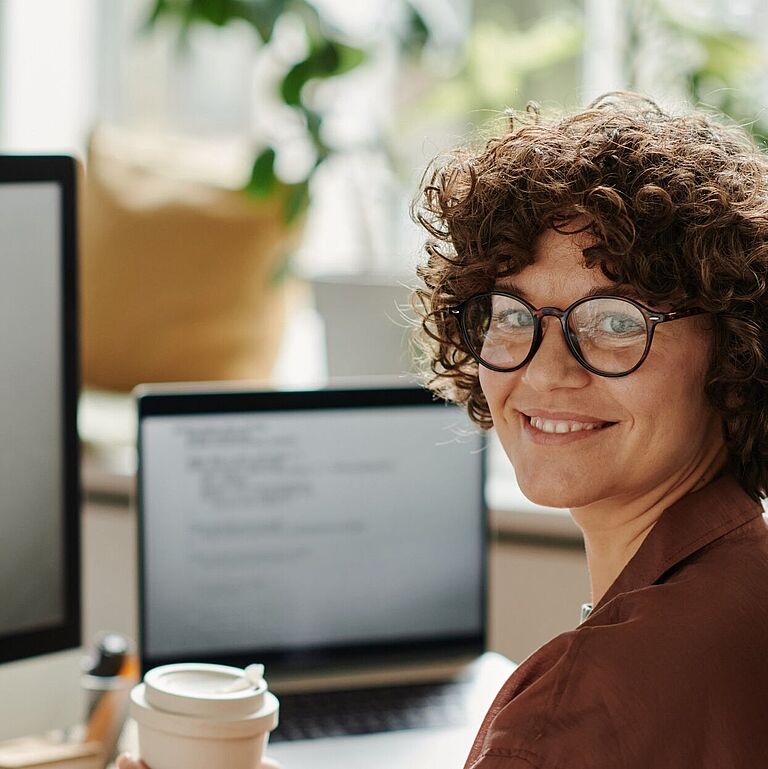 Frau mit Brille am Computerarbeitsplatz