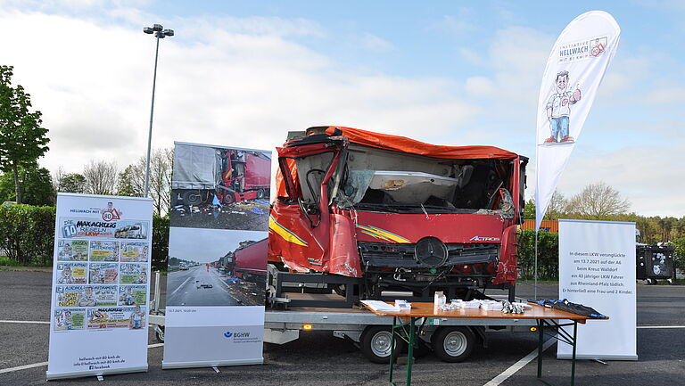 Ein Messestand ist aufgebaut und gezeigt wird eine unfallbedingte zerstörte LKW Kabine.
