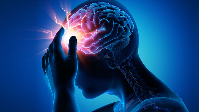 Eine Grafik zeigt einen Schlaganfall im Kopf, hell erleuchtet. Der Mensch fasst sich an die Stirn.