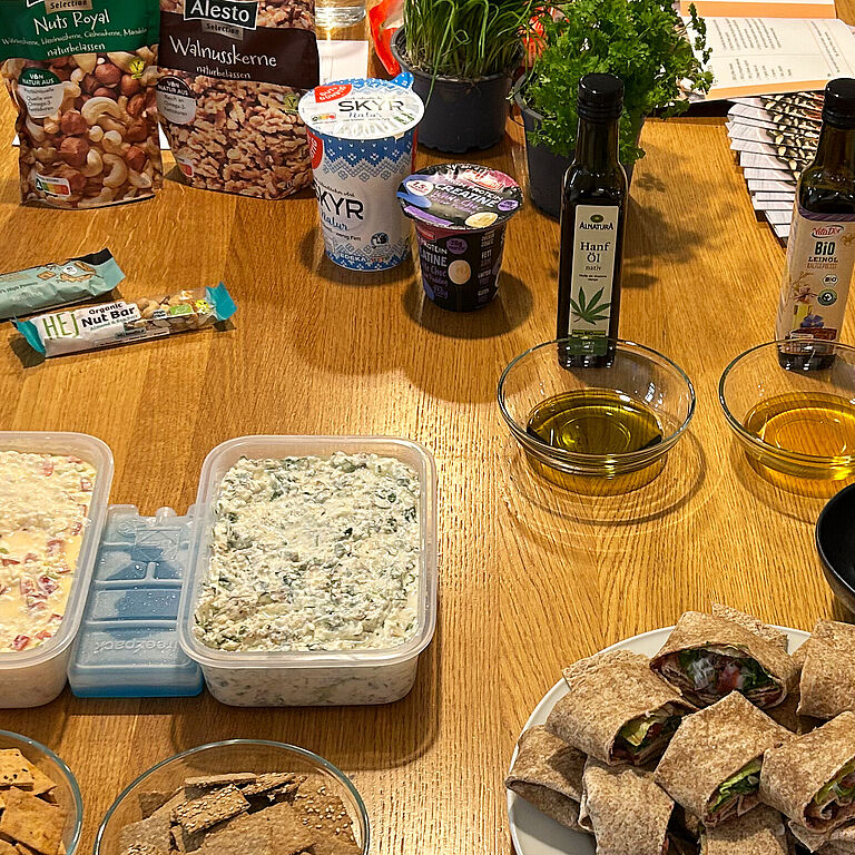 Auf einem Holztisch sind verschiedene Lebensmittel angeordnet.