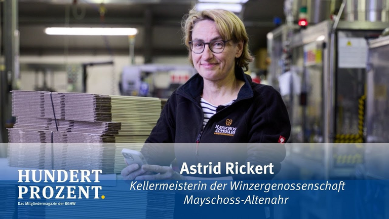 strid Rickertl, Kellermeisterin der Winzergenossenschaft Mayschoss-Altenahr steht in der Produktionshall und schaut freundlich in die Kamera. Sie erklärt, wie sie den Spagat zwischen Wiederaufbau und Weinanbau schaffen. , als sie üdie . 