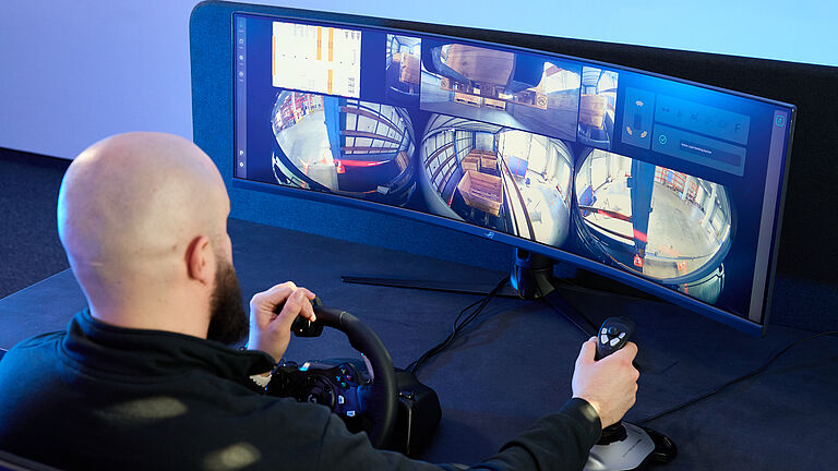 Das Bild zeigt Nik Schmidt, Mitgründer von Enabl, zeigt, der einen Gabelstapler aus der Ferne steuert.