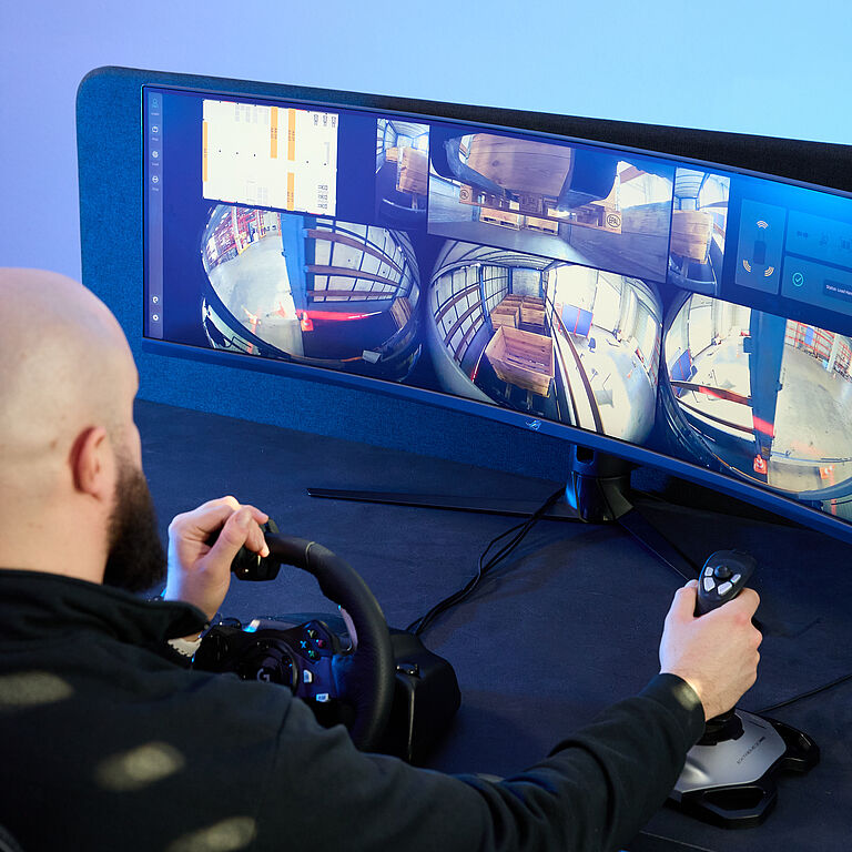 Das Bild zeigt Nik Schmidt, Mitgründer von Enabl, zeigt, der einen Gabelstapler aus der Ferne steuert.