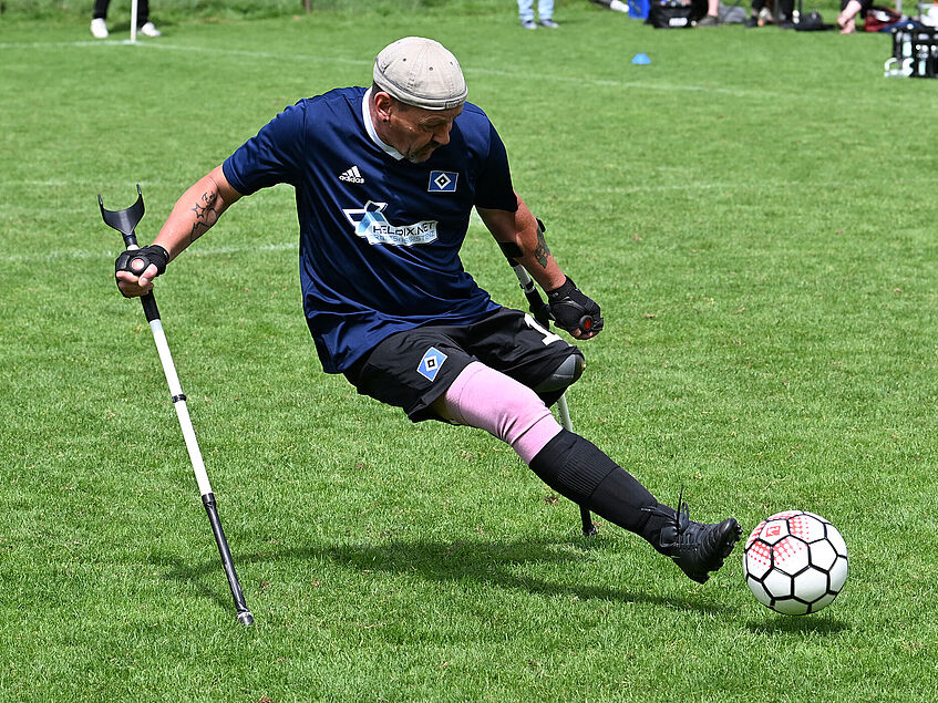 Dirk Boßmeyer spielt für den HSV in der Bundesliga Amputierten-Fußball. Auf einem Rasenplatz nimmt Kurs auf den Ball, der direkt vor seinem linken Fuß liegt. 
