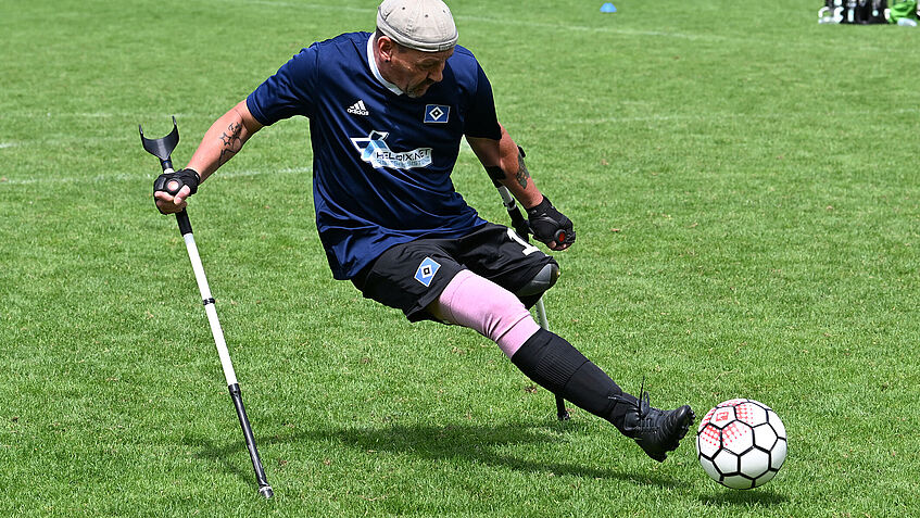 Dirk Boßmeyer spielt für den HSV in der Bundesliga Amputierten-Fußball. Auf einem Rasenplatz nimmt Kurs auf den Ball, der direkt vor seinem linken Fuß liegt. 