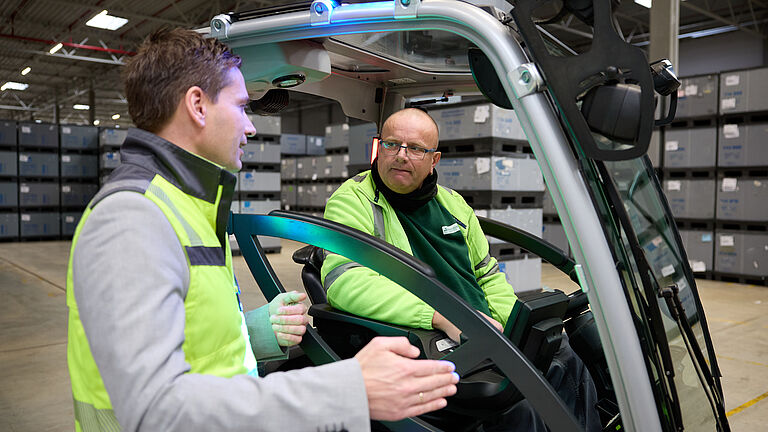 Das Bild zeigt Dr. Michael Demes im Gespräch mit Gabelstaplerfahrer Marius Szoltysik.