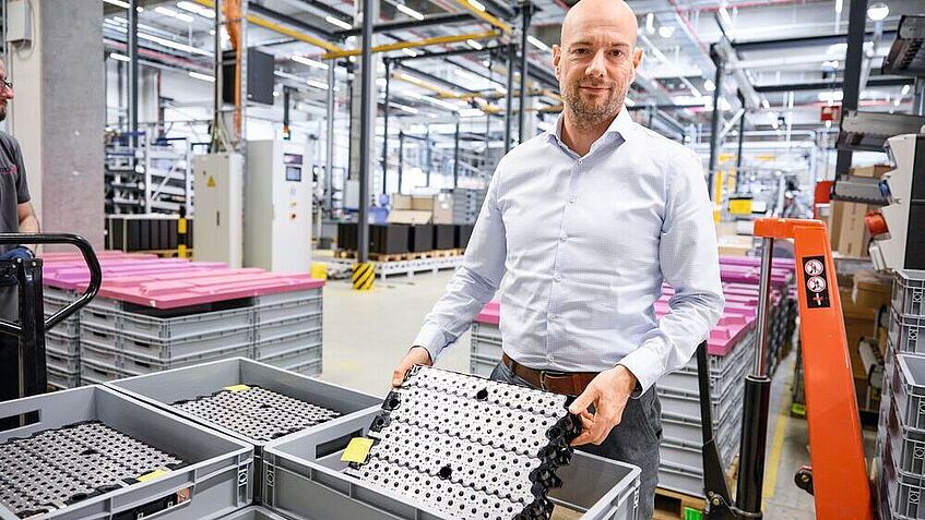 Wolfgang Klüpfel zeigt ein Lithium-Ionen-Batterien-Modul in der Produktionshalle
