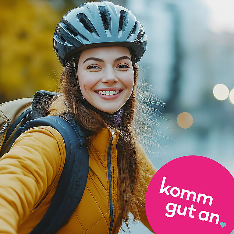 Eine junge Frau mit Fahrradhelm auf dem Kopf lächelt in die Kamera.