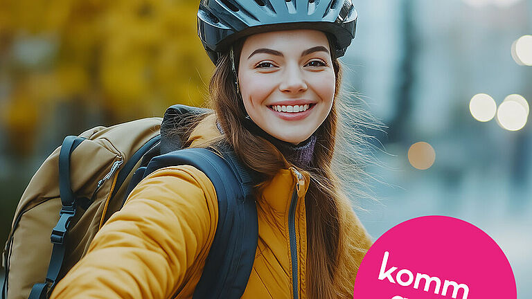 Eine junge Frau mit Fahrradhelm auf dem Kopf lächelt in die Kamera.