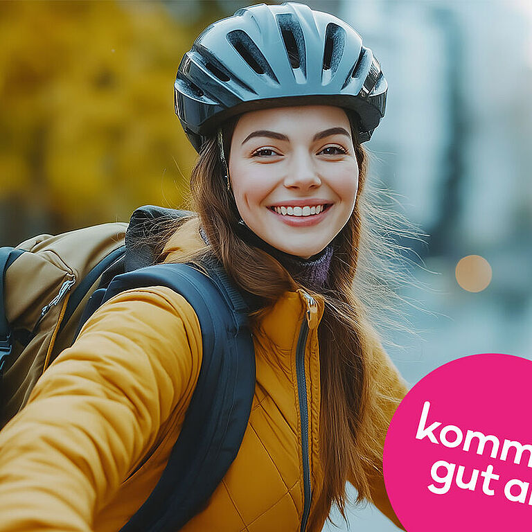Eine junge Frau mit Fahrradhelm auf dem Kopf lächelt in die Kamera.