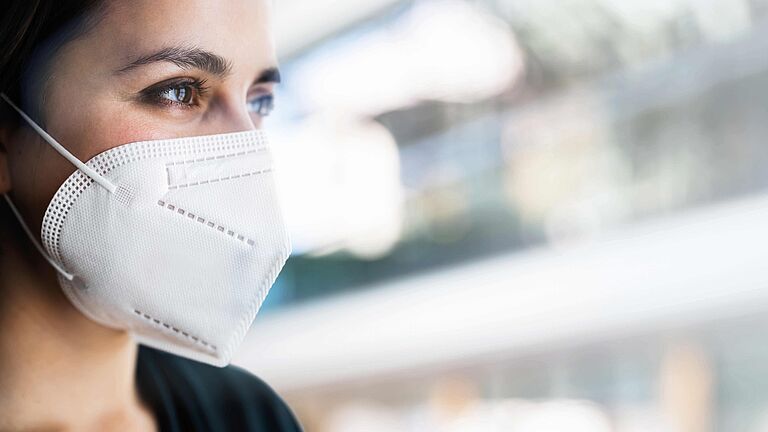Eine junge, dunkelhaarige Frau trägt eine FFP2 Maske