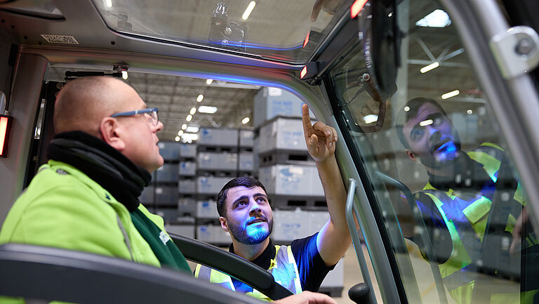 Das Bild zeigt die Gabelstaplerfahrer Marius Szoltysik (links) und Wilat Binnewies im Gespräch