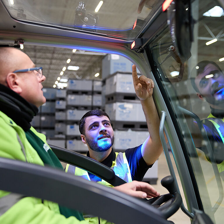 Das Bild zeigt die Gabelstaplerfahrer Marius Szoltysik (links) und Wilat Binnewies im Gespräch