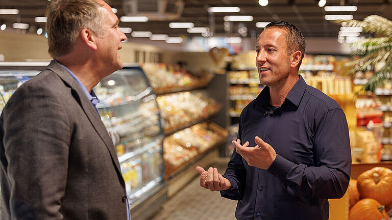 Rewe-Marktbetreiber David Hegemann (rechts) im Gespräch mit Roderich Dörner, Ansprechpartner für Inklusion bei Rewe West