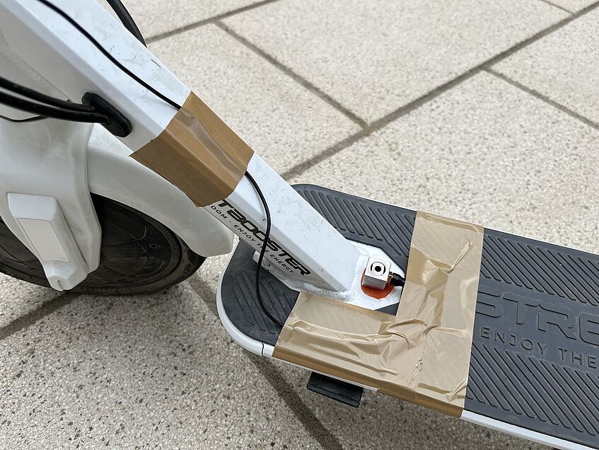 E-Scooter: Hier wurden Kabel provisorisch mit Klebeband am Rahmen und Trittbrett fixiert.