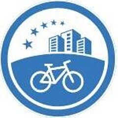 Blau-weißes Rundlogo mit Fahrrad-Symbol im Vordergrund, stilisierten Hochhäusern im Hintergrund und fünf Sternen darüber.