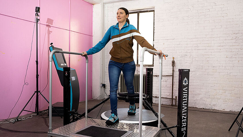 Frau betritt ein omnidirektionales Laufband.