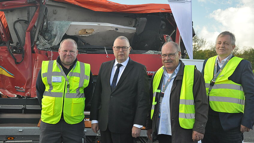 Vier Männer stehen vor dem Exponat LKW Kabine