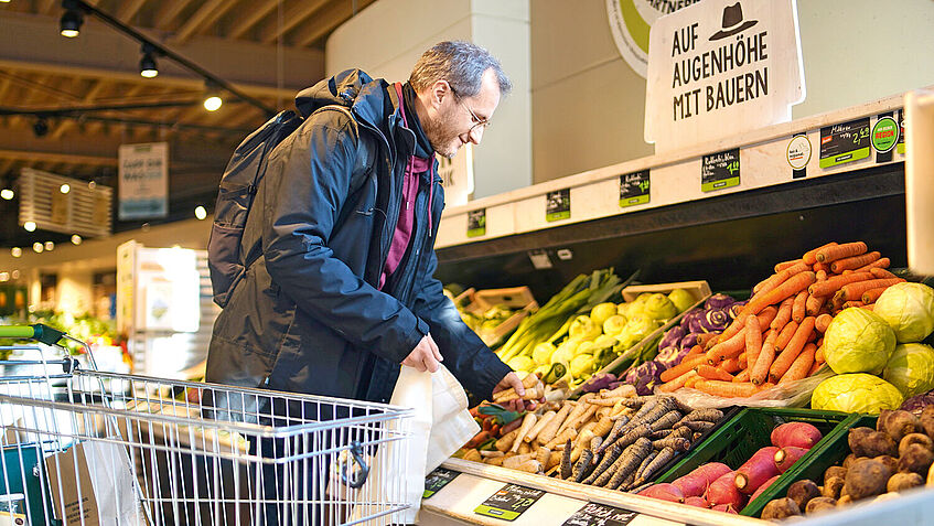 Ein Kunde bedient sich an der Obst- und Gemüsetheke im Supermarkt der Bio Company.