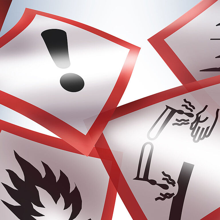 Fünf GHS Gefahrstoffsymbole sind auf blauem Hintergrund fliegend abgebildet