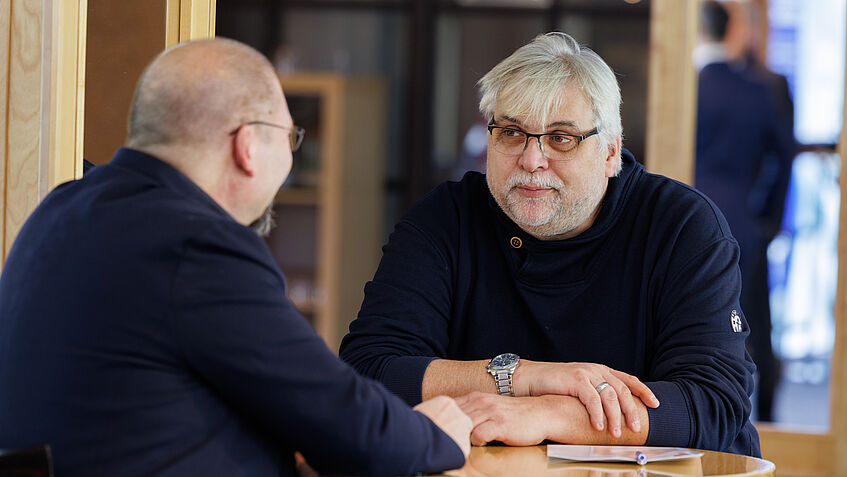 Zwei Teilnehmer der Schulungsveranstaltung unterhalten sich.