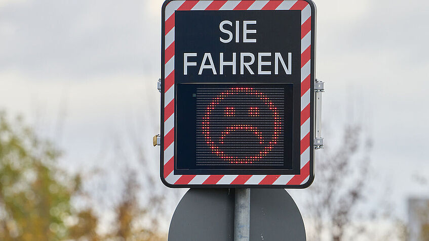 Detailaufnahme: Display einer Geschwindigkeitsanzeigetafel mit rotem Smiley