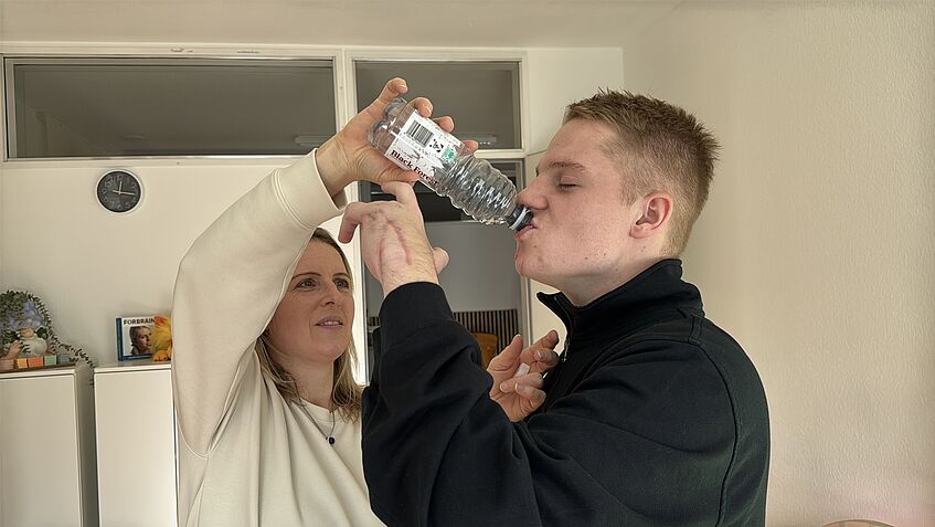 Martina Eberhard setzt ihrem Sohn die Wasserflasche auf den Mund.