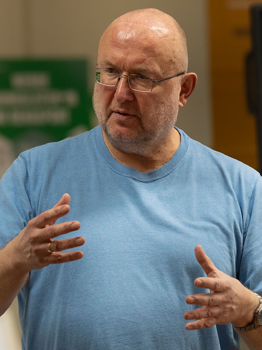 Seminarleiter Dr. Georg Schick erklärt und gestikuliert mit den Händen.