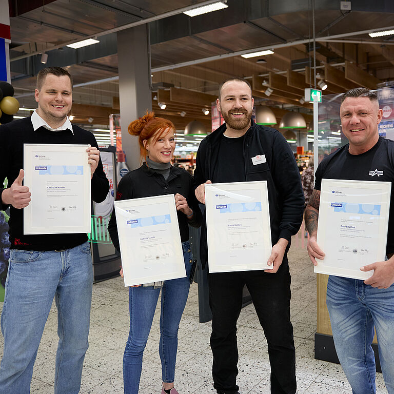 Gruppenbild von vier Ersthelfern, die jeweils mit ihrer BGHW-Urkunde posieren