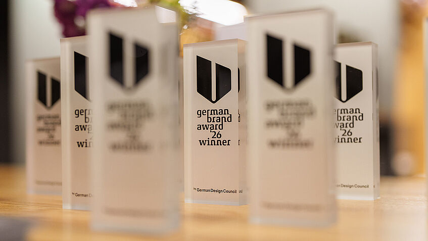 Auf einem Tisch stehen mehrere Awards des German Brand Awards