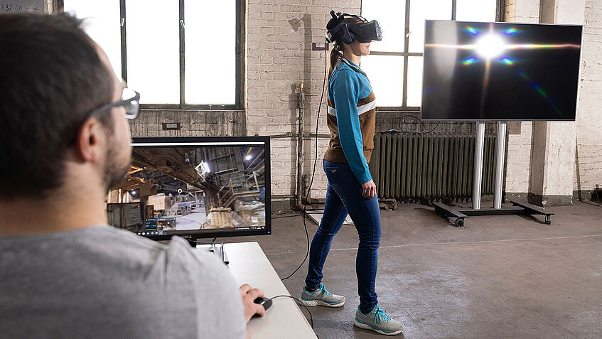 Frau trägt eine VR-Brille und orientiert sich im Raum.