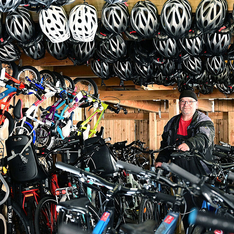 Blick in einen Fahrradladen mit vielen Helmen an der Decke
