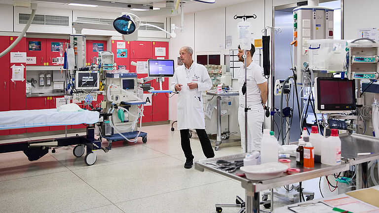 Dr.christoph Reimertz steht im Schockraum und erklärt die Abläufe im Falle eines Notfalls.. In dem fensterlosen Raum stehen Behandlungstisch, Infusionen, Überwachungsmonitore, Röntgen- und Beatmungsapparate 
