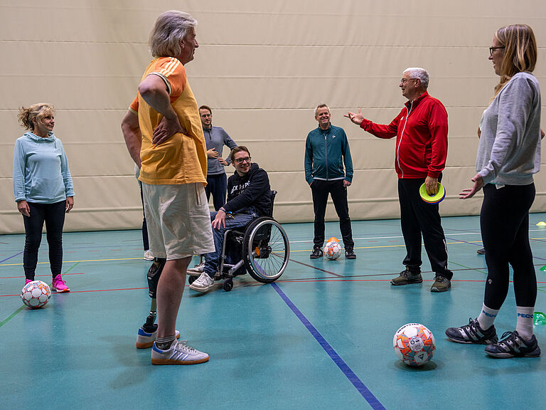 Balltraining in einer Sporthalle: Auch ein Prothesenträger und ein Rollstuhlfahrer nehmen teil.