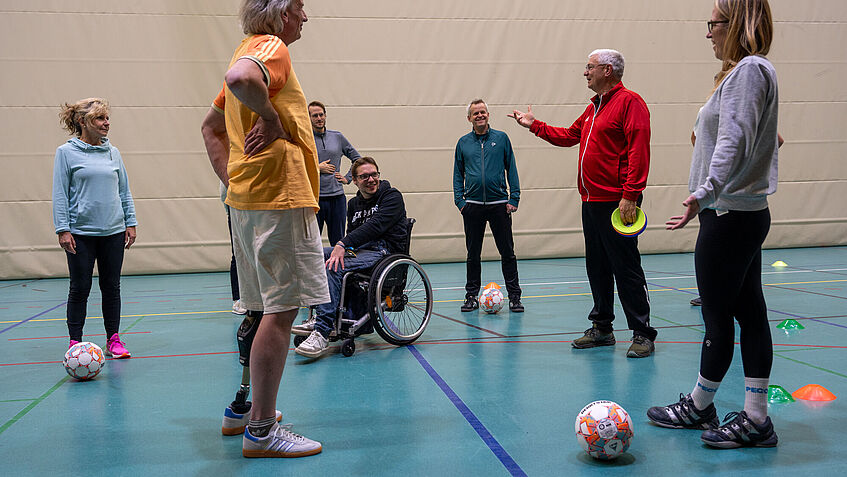 Balltraining in einer Sporthalle: Auch ein Prothesenträger und ein Rollstuhlfahrer nehmen teil.