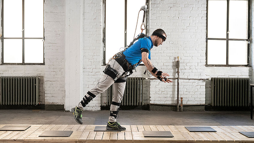 Ein Mann in einem Ganzkörpermessanzug geht einen Stolperparcour entlang.